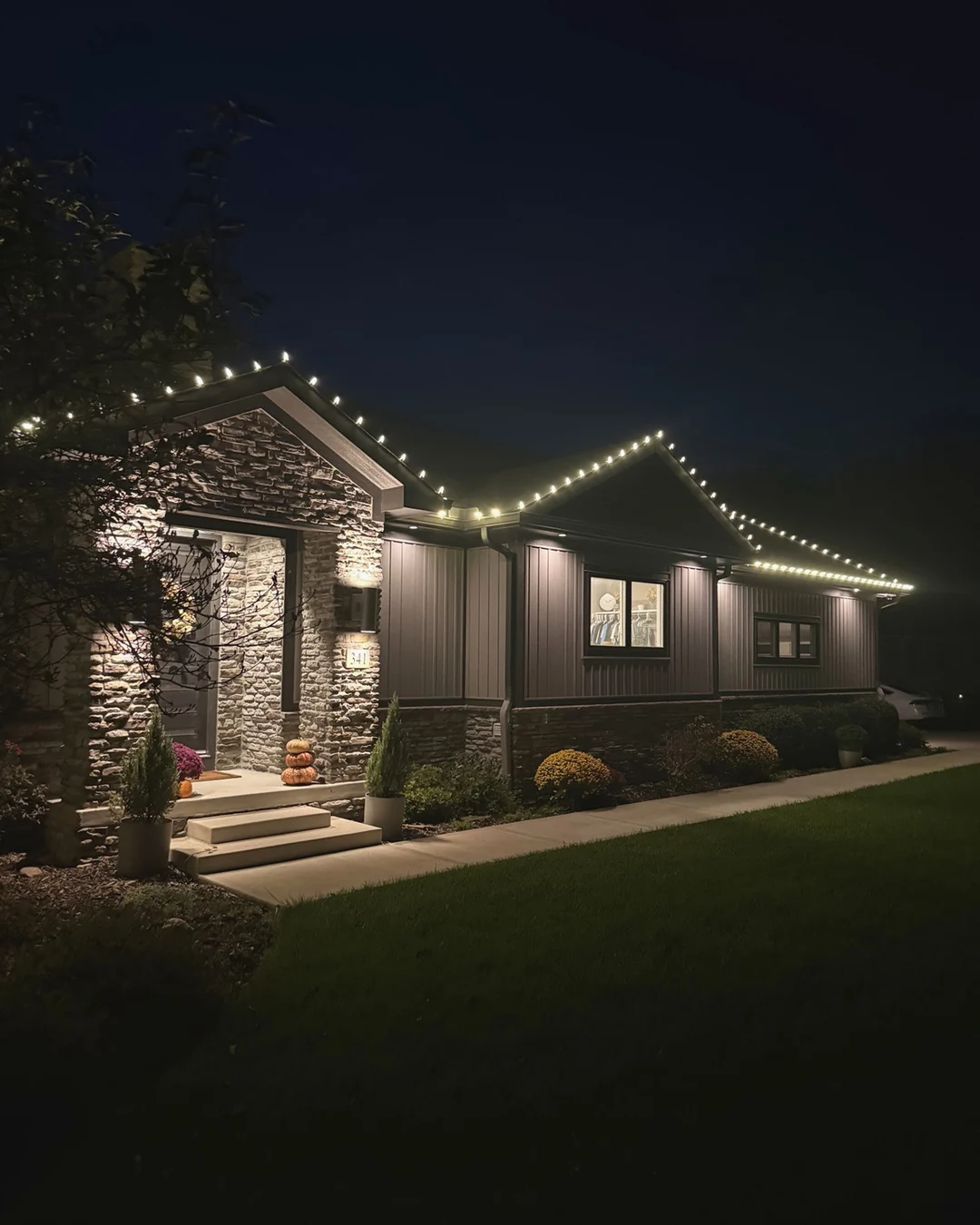 Warm-white Christmas lights installed along a roofline by Summit Wash.