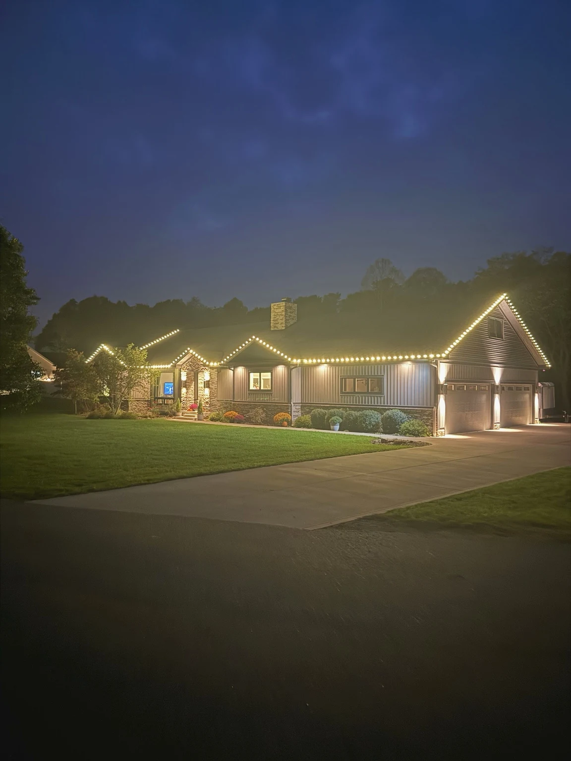 Wide view of a home lit with professionally installed Christmas lighting.