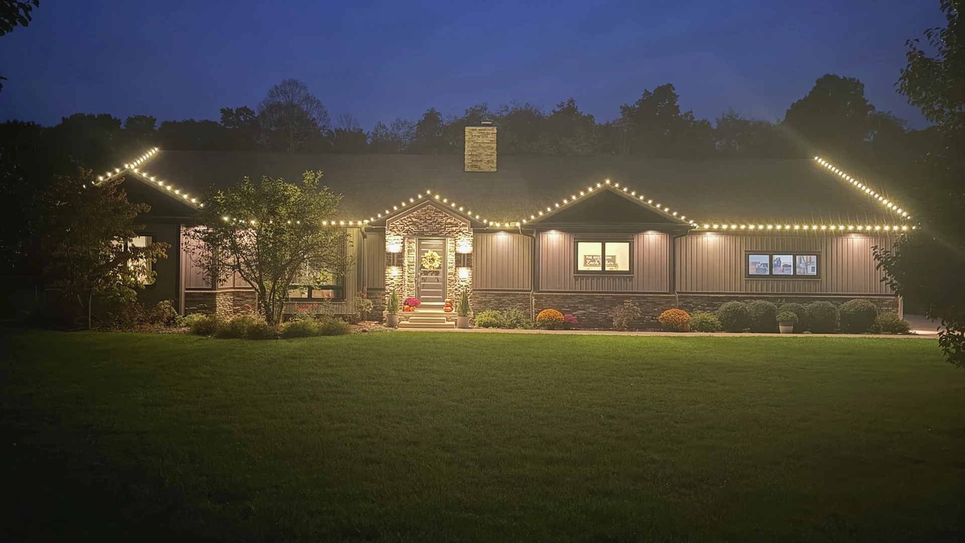 A home in southern Ohio at night with warm-white Christmas lights installed by Summit Wash along the roofline.